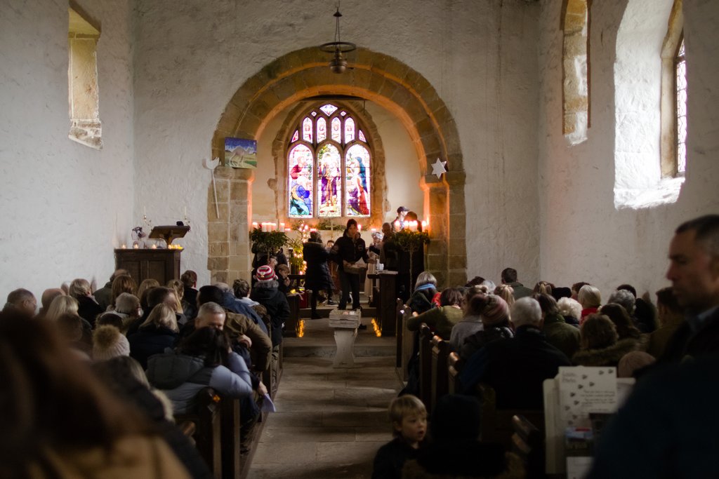 A choir singing by candlelight in an historic chapel