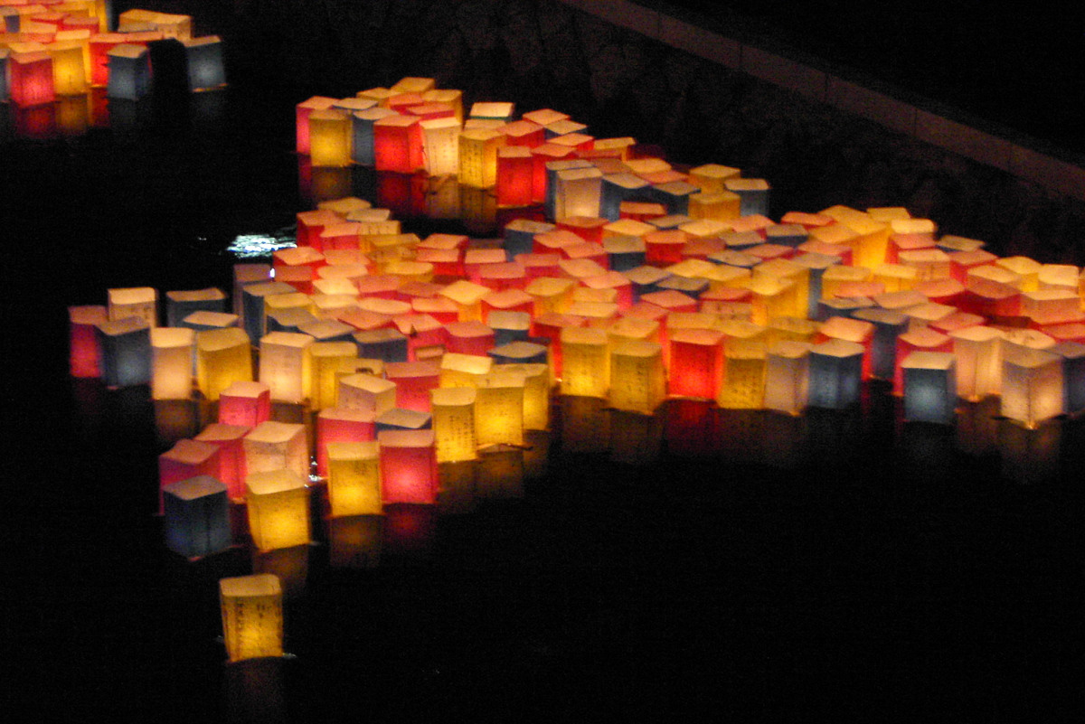 People releasing lanterns into the night sky at a lantern festival
